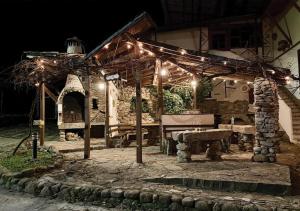 a stone pavilion with a bench under a group of lights at Арт Спектър Камп in Bratsigovo