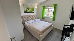 a small bedroom with a bed and a window at Apartment Stella in Ražanj