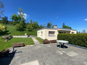a house with a patio with benches and a table at Villa panorama 1000 in La Chaux-de-Fonds