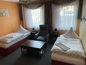 a hotel room with a bed and a chair at Gasthof und Pension Bernburger Point in Bernburg +6 photos