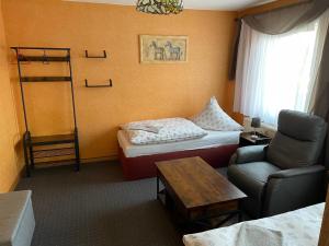 a room with a room with a bed and a chair at Gasthof und Pension Bernburger Point in Bernburg