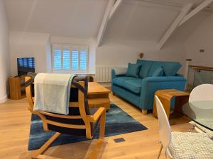 a living room with a blue couch and a table at The Hayloft, Noss Mayo in Plymouth
