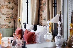 a bedroom with a bed with red pillows and a mirror at Domaine de Locguénolé & Spa - Relais & Chateaux in Kervignac