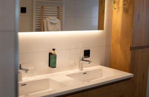a bathroom with a white sink and a mirror at B&B Oud-Zilven Het Vogelhuisje in Loenen +12 photos