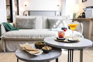 a living room with two tables with food and a drink at Le Celtique & Spa in Carnac