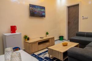 a living room with a couch and a tv on the wall at Résidence Madior F2 in Dakar