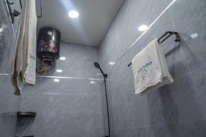 a bathroom with a shower with a towel on the wall at Résidence Madior F2 in Dakar +13 photos