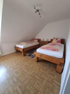 two twin beds in a room with wooden floors at Ferienwohung Else Sankt Wendel in Sankt Wendel +2 photos