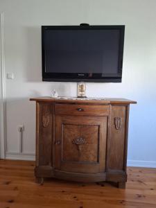 a flat screen tv on top of a wooden cabinet at Ferienwohung Else Sankt Wendel in Sankt Wendel