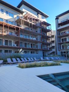an apartment building with lounge chairs and a swimming pool at Departamento de mar- UF5-La Reserva Almarena in Costa del Este