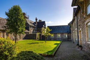 a courtyard of an old stone building with a grass yard at The Hayloft, Noss Mayo in Plymouth