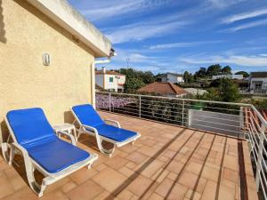 a patio with two blue chairs on a balcony at Casa de Maria in Cotovia