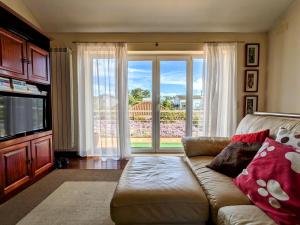 a living room with a couch and a large window at Casa de Maria in Cotovia