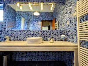 a blue tiled bathroom with a sink and a mirror at Casa de Maria in Cotovia
