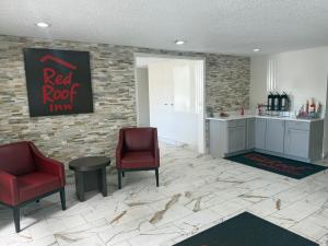 a waiting room with two red chairs and a counter at Red Roof Inn & Suites Hammond, IN in Hammond