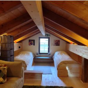 a attic bedroom with two beds and a couch at Ferienhaus Träglhof in Hirschau