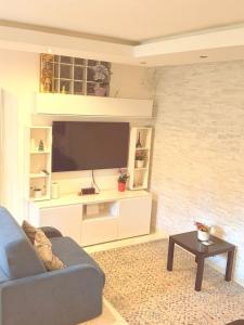 a living room with a blue couch and a tv at Lo Scorcio su Sovicille in Sovicille +5 photos