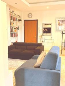 a living room with a couch and a clock on the wall at Lo Scorcio su Sovicille in Sovicille