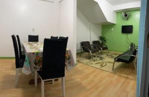 a dining room with a table and chairs and green walls at Espaço Ideal 4 in Cascavel