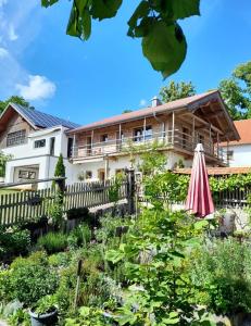 a garden in front of a house with an umbrella at Ferienhaus Träglhof in Hirschau