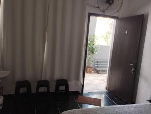 a room with a door and some chairs and a window at Espaço Ideal 4 in Cascavel