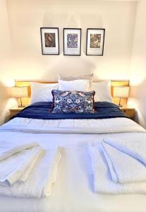 a bedroom with a large bed with white sheets and pillows at The Inn at Emmington in Chinnor