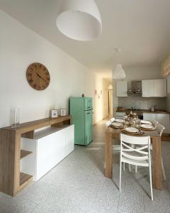 a kitchen with a table and a clock on the wall at Cordi Casa Vacanze in Giulianova