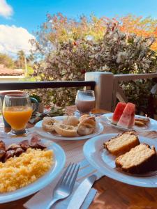 a table with plates of food and drinks on it at Pousada Boldró Home in Fernando de Noronha