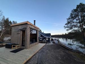 a tiny house on a dock next to a lake at Hamsun Panorama med sauna in Åmli