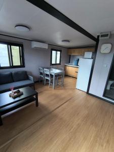 a living room with a couch and a table and a kitchen at Studio MAT in Herly