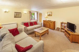 a living room with a couch and a tv at Old Malthouse Monksilver in Monksilver