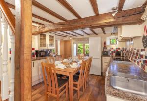 a kitchen with a wooden table and chairs and a sink at Old Malthouse Monksilver in Monksilver