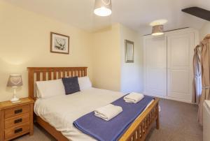 a bedroom with a bed with two towels on it at Old Malthouse Monksilver in Monksilver