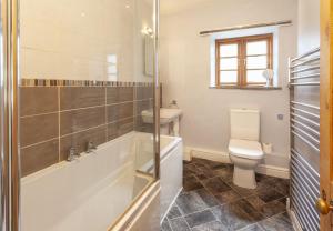 a bathroom with a shower and a toilet and a sink at Old Malthouse Monksilver in Monksilver +13 photos