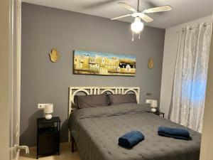 a bedroom with a bed with two blue pillows on it at playa ancha in San Luis de Sabinillas +20 photos