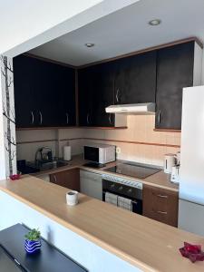 a kitchen with black cabinets and a counter top at playa ancha in San Luis de Sabinillas