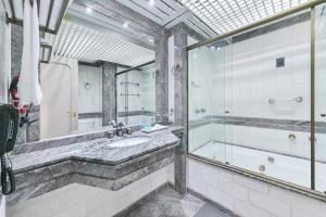 a bathroom with a tub and a sink and a shower at Hotel Golden Park Campinas Cambuí By Nacional Inn in Campinas