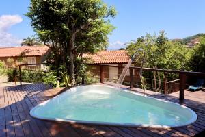 a hot tub with a water fountain on a deck at Calador Búzios Hotel in Búzios +27 photos
