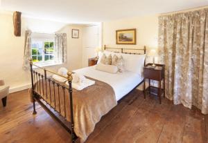 a bedroom with a large bed and a window at Syms Cottage Cutcombe in Cutcombe