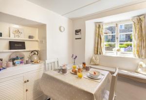 a dining room with a table and a window at Syms Cottage Cutcombe in Cutcombe