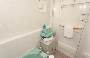 a white bathroom with a sink and a bath tub at Syms Cottage Cutcombe in Cutcombe +20 photos