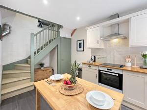 a kitchen with a table with a bowl of fruit on it at Worthy Cottage Porlock Weir in Porlock +9 photos