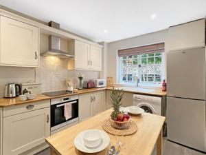 a kitchen with a table with a bowl of fruit on it at Worthy Cottage Porlock Weir in Porlock