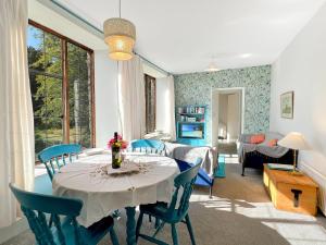 a dining room with a table and blue chairs at Barn Cottage Brayford in Charles +28 photos
