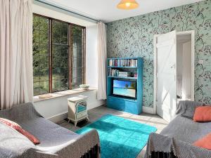 a bedroom with two beds and a tv and a window at Barn Cottage Brayford in Charles