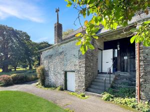 a stone house with a garage and a door at Barn Cottage Brayford in Charles
