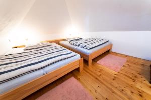 two beds in a room with wooden floors at Chalet Němčice in Němčice