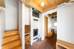 a fireplace in the middle of a living room with wooden ceilings at Chalet Němčice in Němčice