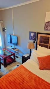 a bedroom with a bed and a desk with a computer at Little Haven! in Rustenburg