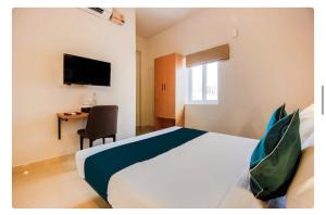 a bedroom with a bed and a desk and a television at Hotel Silverkey luxury Rooms in Hyderabad